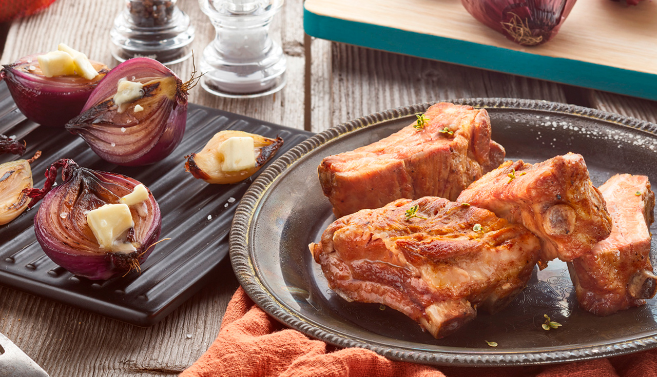 Costine di maiale tradizionali con cipolle e scalogni confit